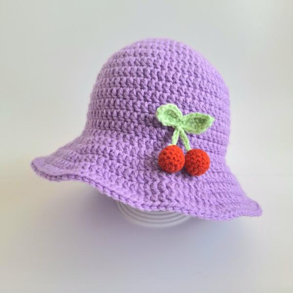 Gehaakte baby hoedje twee-in-een | Lila met kersjes en oranje bloemetje