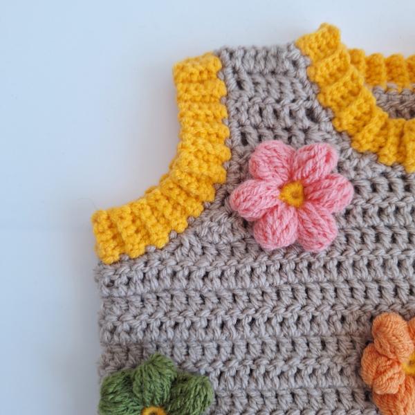 Gehaakt baby vestje | Beige en geel met lichtroze, groene en oranje bloemen
