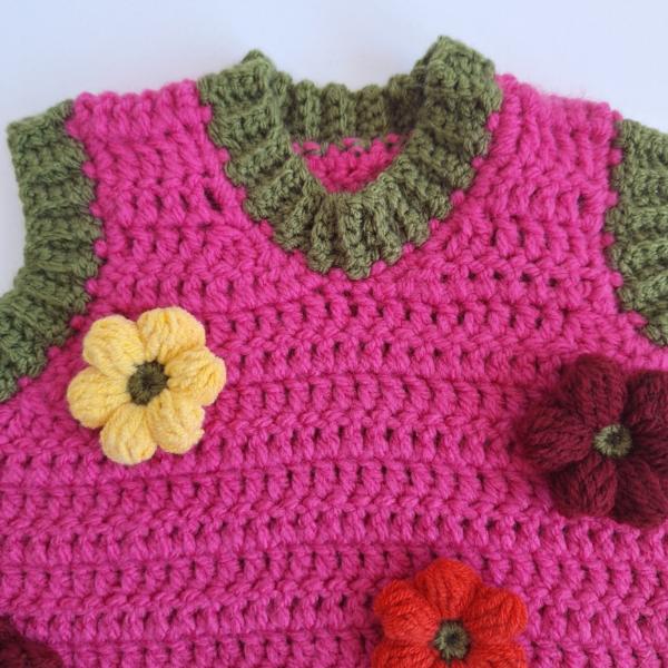 Gehaakt baby vestje | Fuchsia en donkergroen met gele, wijnrode en knalrode bloemen