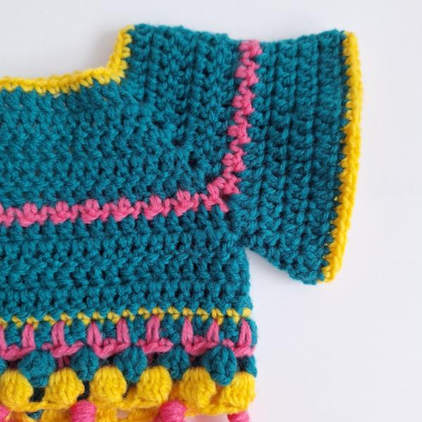 Gehaakt baby vestje | Petrol, roze en geel met roze franjes