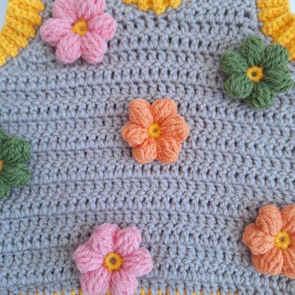 Gehaakt baby vestje | Beige en geel met lichtroze, groene en oranje bloemen