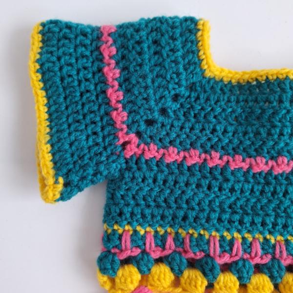 Gehaakt baby vestje | Petrol, roze en geel met roze franjes